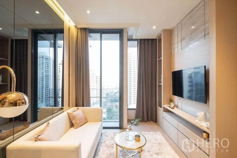 公寓 出租在Watthana, Bangkok - 客厅电视背景墙，阳台推拉门与全高窗帘。