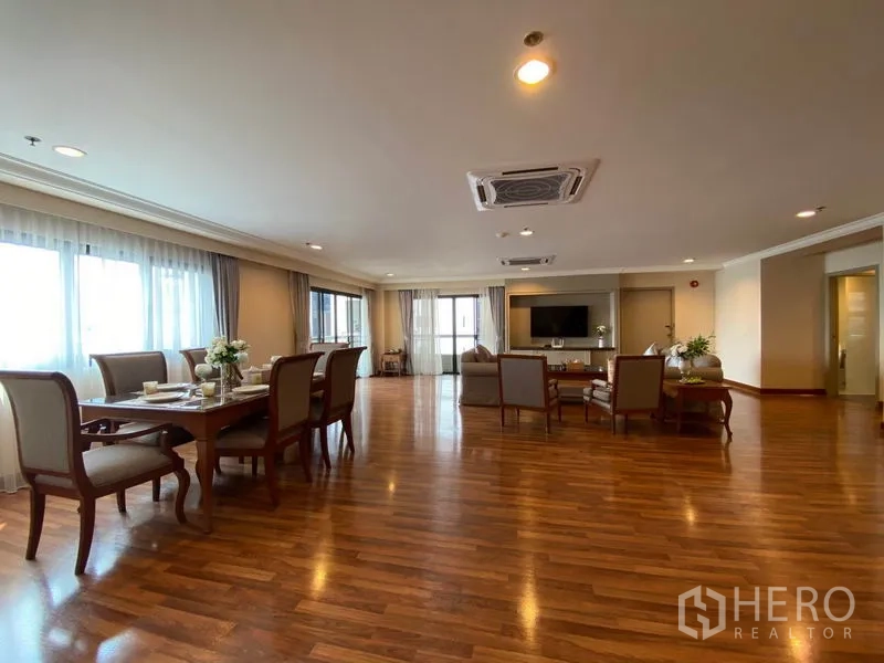 公寓 出租在Watthana, Bangkok - 宽敞的客餐一体空间，实木地板，大窗户，吊顶嵌入式空调与电视墙。