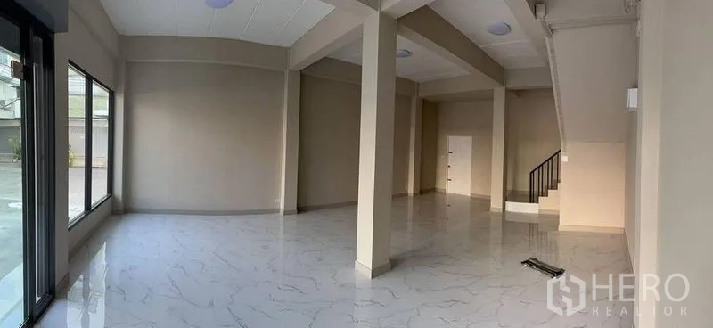 店屋 出租在Bang Kapi, Bangkok - 宽敞底层展厅，落地窗与承重柱。