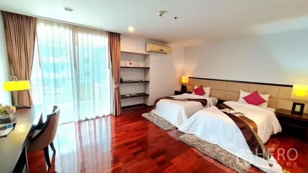อพาร์ทเมนท์ ให้เช่าในWatthana, Bangkok - ห้องนอนกว้าง เตียงคู่ พื้นไม้ โต๊ะทำงาน และประตูกระจกบานเลื่อนออกระเบียง