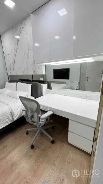 Condominium for rent in Watthana, Bangkok - Bedroom workstation with large desk, ergonomic chair and overhead cabinets.