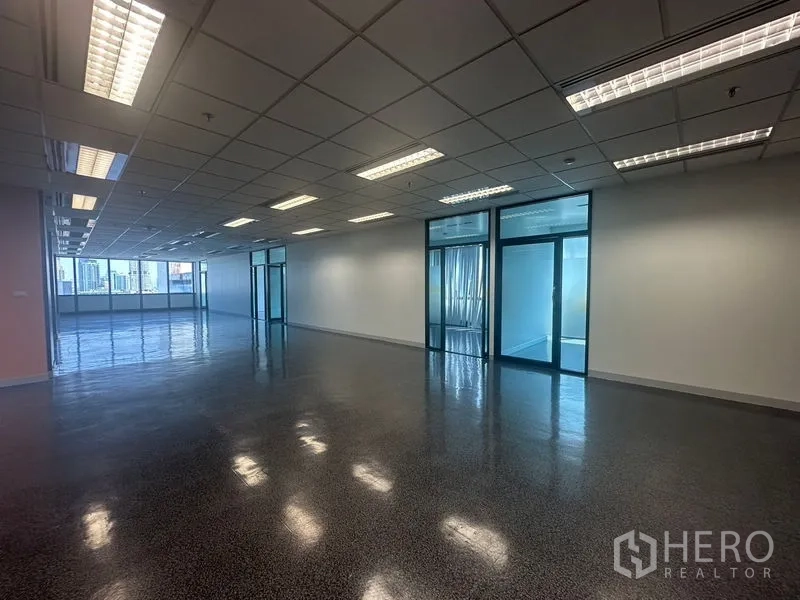 Office Space for rent in Khlong Toei, Bangkok - Open-plan area with glass-door offices and skyline views at the far end.