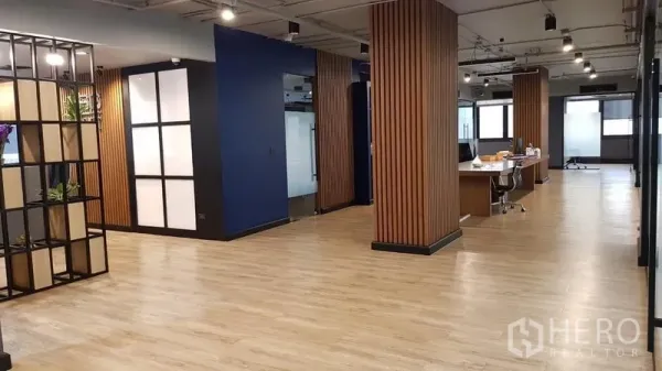 Office Space for rent in Khlong Toei, Bangkok - Open-plan office with wood slat columns, task lighting and shared desks on light wood floors.