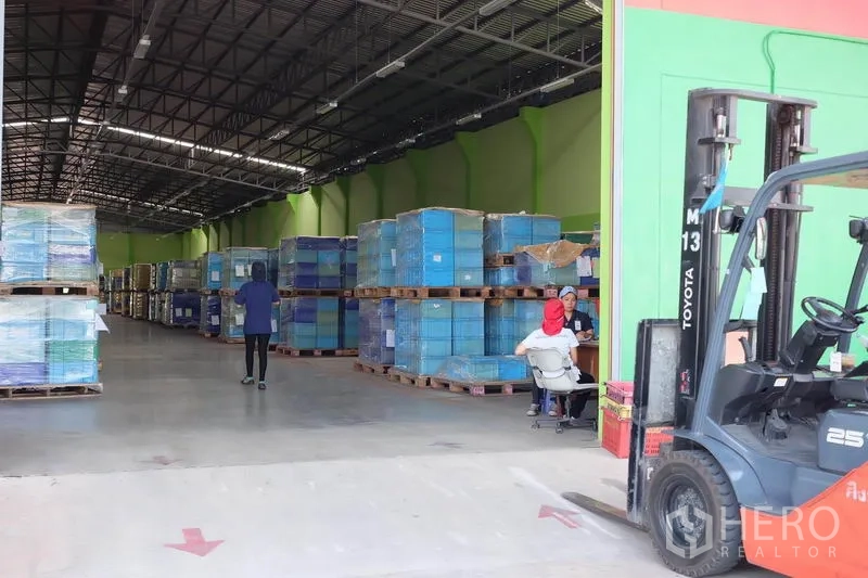 คลังสินค้า ให้เช่าในBan Phaeo, Samut Sakhon - รถโฟล์คลิฟต์ที่ทางเข้าขนถ่ายสินค้า ข้างพาเลทพันฟิล์ม ภายในทางเดินโกดังกว้างและสว่าง