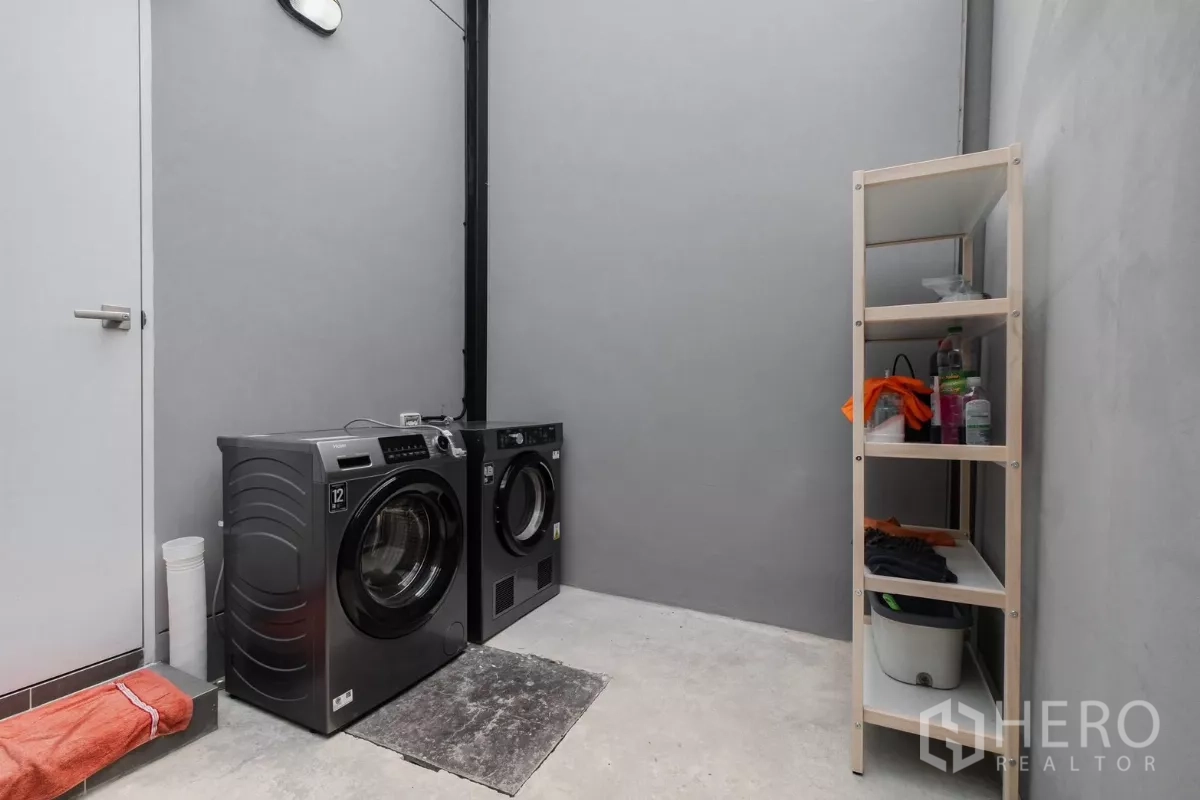 Detached House for rent or sale in Prawet, Bangkok - Laundry area with front-load washer, dryer and storage shelf