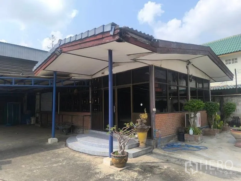 คลังสินค้า ให้เช่าในLat Lum Kaeo, Pathum Thani - อาคารสำนักงานหน้ากระจกพร้อมกันสาด ข้างทางเข้าโกดัง จัดสวนกระถางต้นไม้