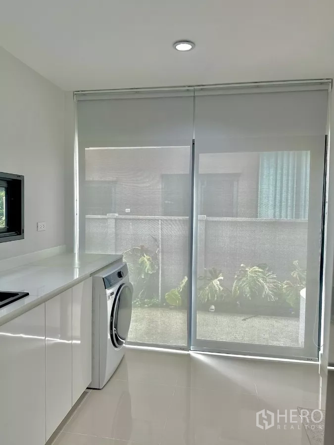 独立式住宅 出租或出售在Prawet, Bangkok - 小厨房连接滑动玻璃门到庭院，配前开门洗衣机。