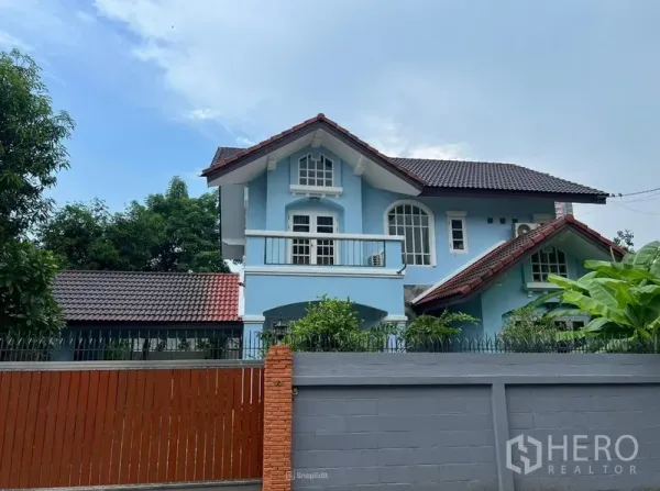 บ้าน ให้เช่าในBang Na, Bangkok - ภาพระยะใกล้ตัวบ้านสีฟ้าสองชั้นพร้อมระเบียงและหน้าต่างโค้ง