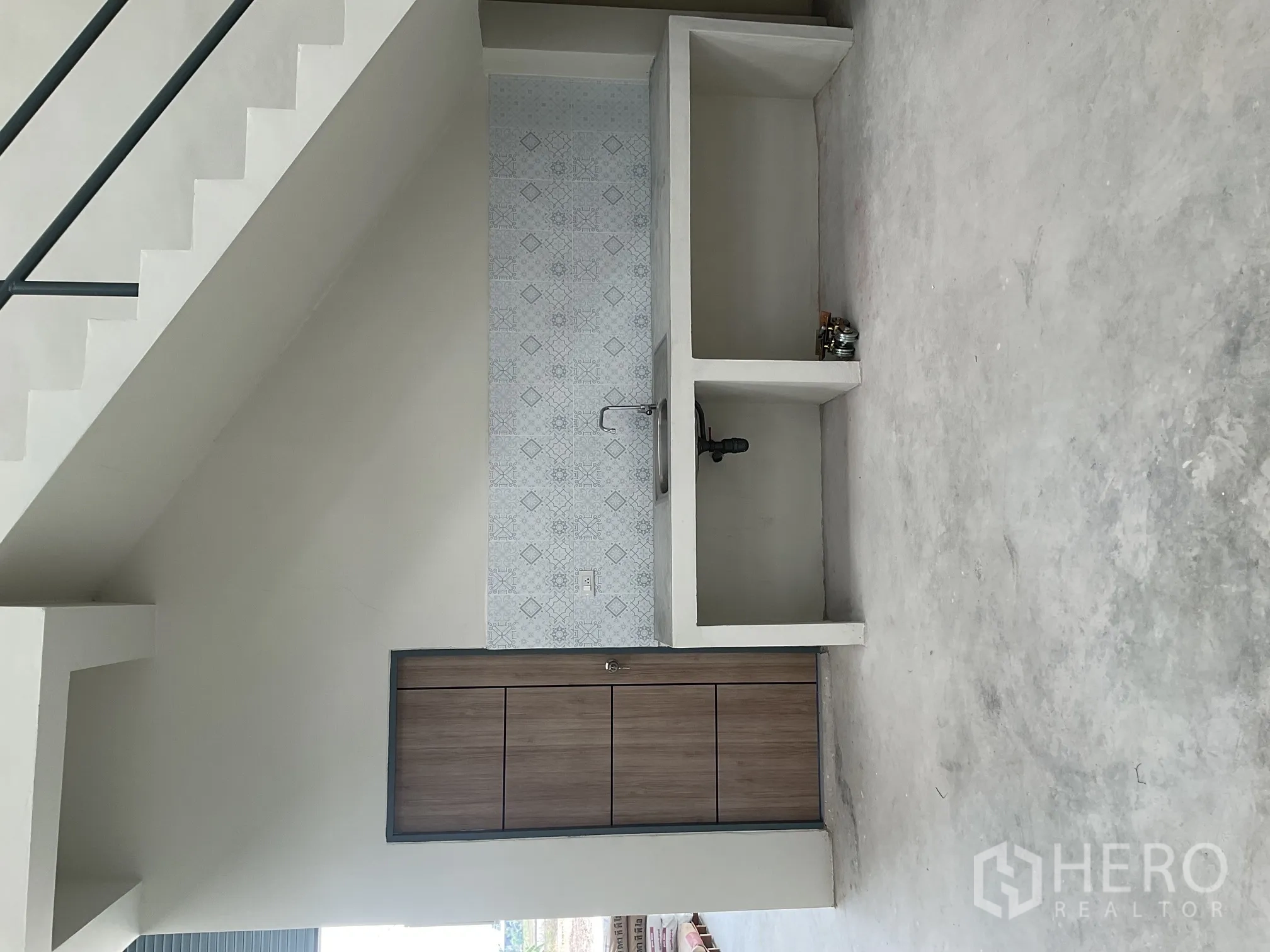 Warehouse for rent in Lat Lum Kaeo, Pathum Thani - Pantry sink with tiled backsplash and concrete counters under the stairs.