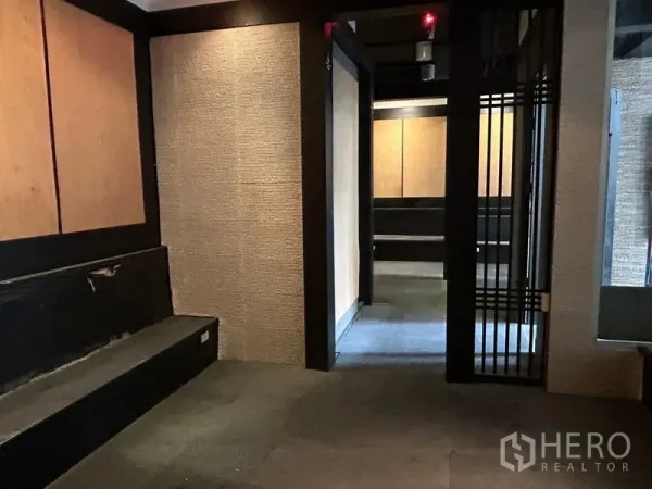 零售空间 出租在Bang Rak, Bangkok - 零售单元内的私密区域，肌理墙、内置长凳与可滑动的格栅门。