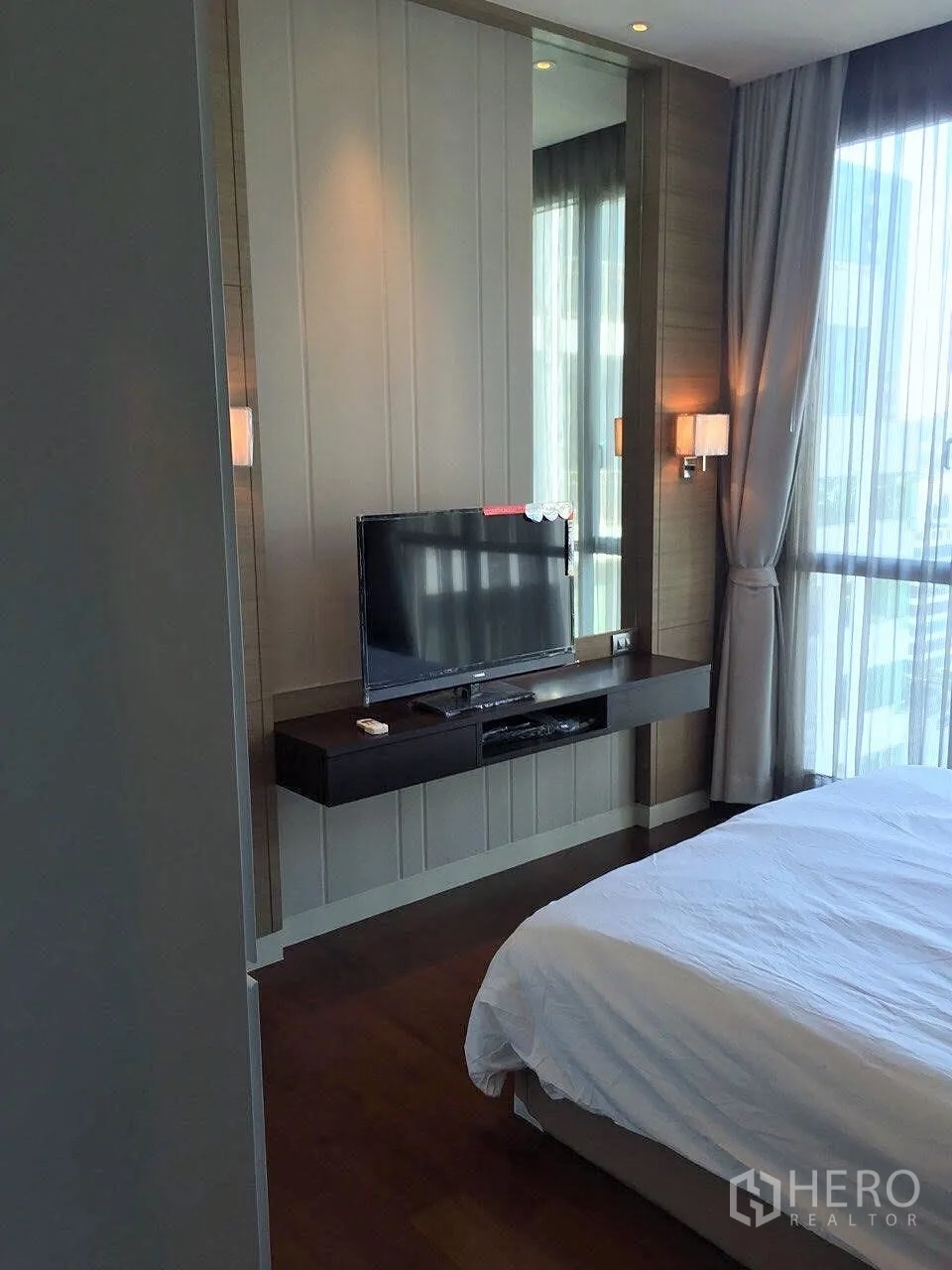คอนโด ให้เช่าในWatthana, Bangkok - ห้องนอนอบอุ่น หน้าต่างบานใหญ่ เตียงปูผ้าขาว และทีวีติดผนังบนชั้นลอย