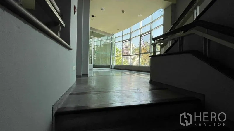 Warehouse for rent or sale in Bangkok Yai, Bangkok - Stair landing to office zone with floor-to-ceiling windows bringing natural light.