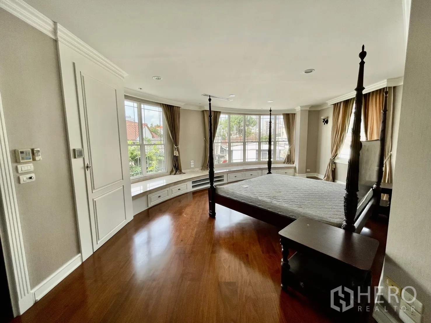Detached House for rent in Chatuchak, Bangkok - Spacious bedroom with bay window seat and a four-poster bed.