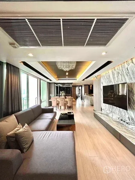 公寓 出售在Watthana, Bangkok - 开放客餐厅，转角沙发、阳台落地窗与大理石装饰墙。