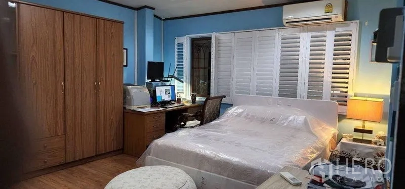 Detached House for rent in Bang Kapi, Bangkok - Blue-themed bedroom with wardrobe, desk and air-conditioning.