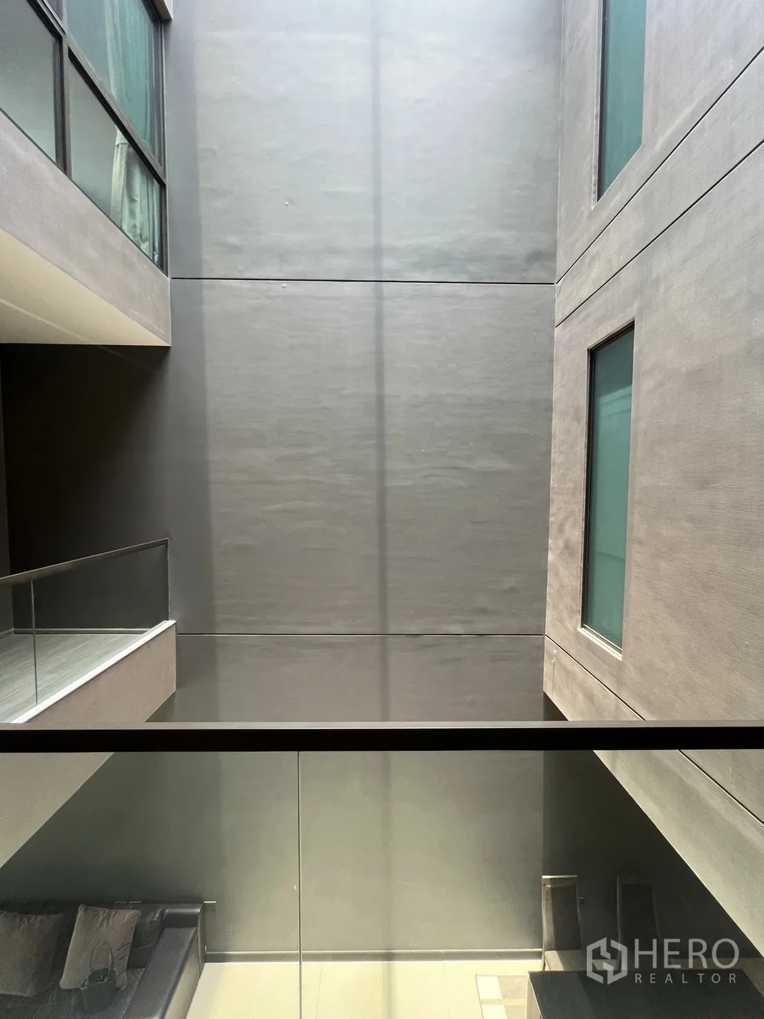 Townhouse for rent in Lat Phrao, Bangkok - Interior atrium with glass balustrades and frosted windows bringing natural light between floors.