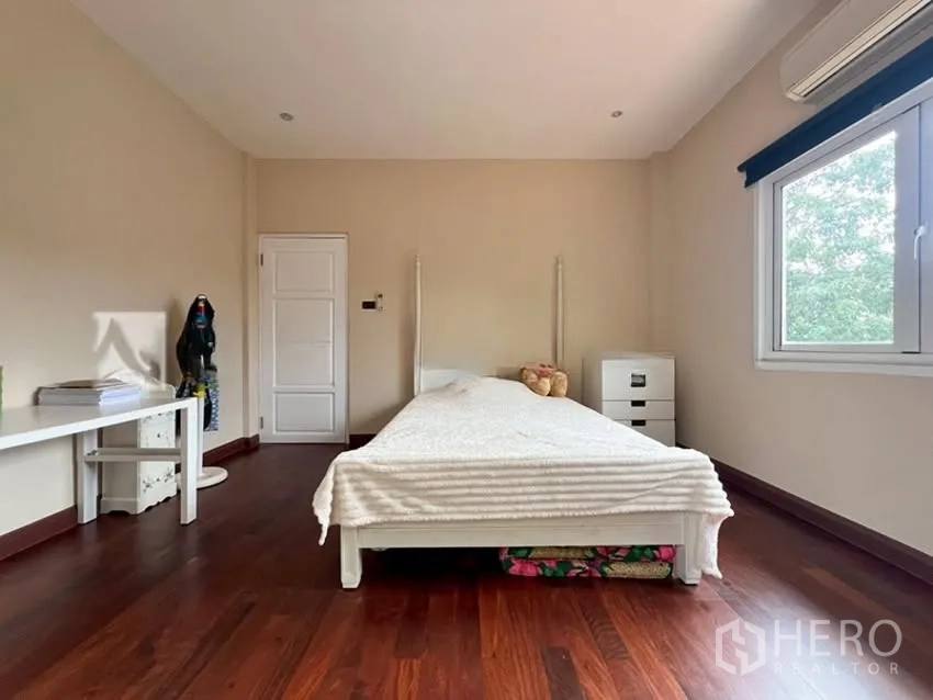 Detached House for rent in Phra Khanong, Bangkok - Bedroom with wooden flooring, single bed, and window to garden views.