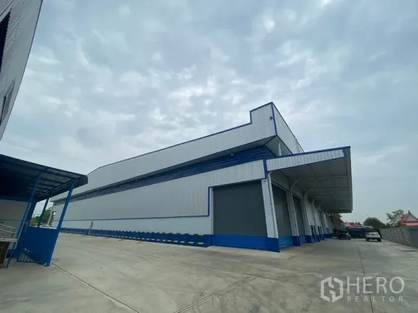 Warehouse for rent in Pathum Thani - Full exterior of the warehouse highlighting dock‑high bays and a clear, open driveway.