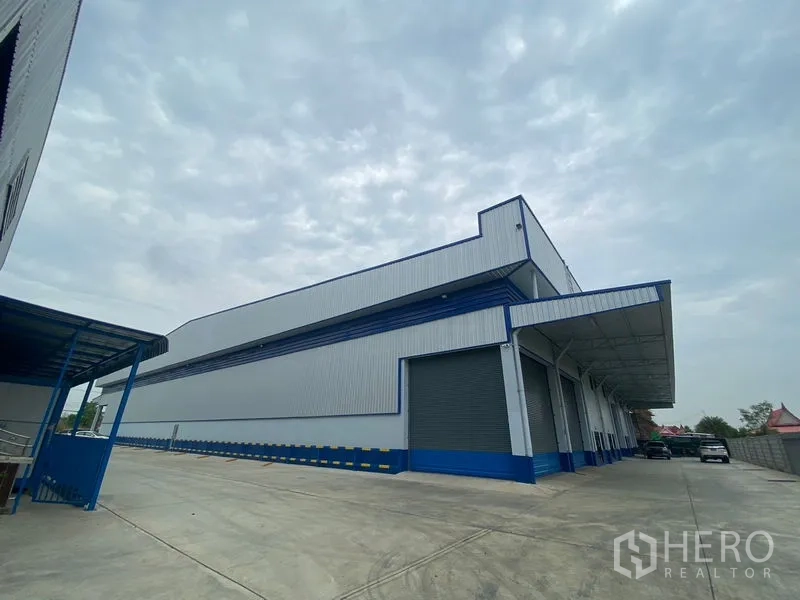 Warehouse for rent in Pathum Thani - Full exterior of the warehouse highlighting dock‑high bays and a clear, open driveway.
