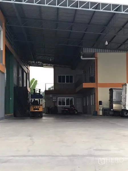 Factory for sale in Pak Kret, Nonthaburi - Spacious covered loading zone connecting to an office block and warehouse.