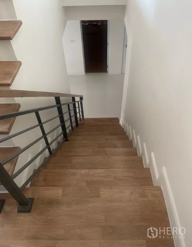 Detached House for rent or sale in Saphan Sung, Bangkok - Top-down view of the staircase with metal railing and wooden steps.