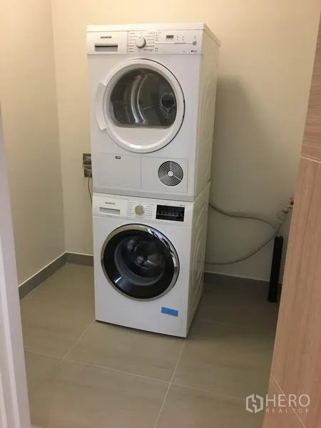 Condominium for rent in Pathum Wan, Bangkok - Laundry room with stacked Siemens washer and dryer for added convenience.