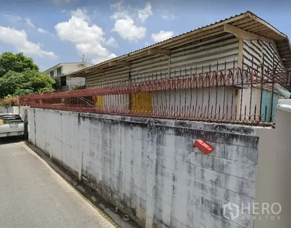คลังสินค้า ให้เช่าในBang Sue, Bangkok - ภาพจากถนนเห็นโกดังชั้นเดียวหลังกำแพงคอนกรีตพร้อมลวดหนาม ย่านบางซื่อ