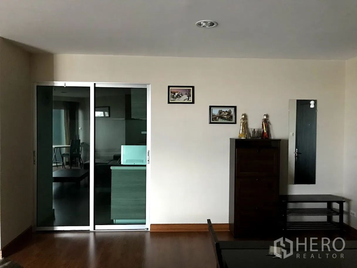 คอนโด ให้เช่าในHuai Khwang, Bangkok - ผนังห้องนั่งเล่นพร้อมประตูกระจกสไลด์เข้าครัว และตู้เก็บของตกแต่ง