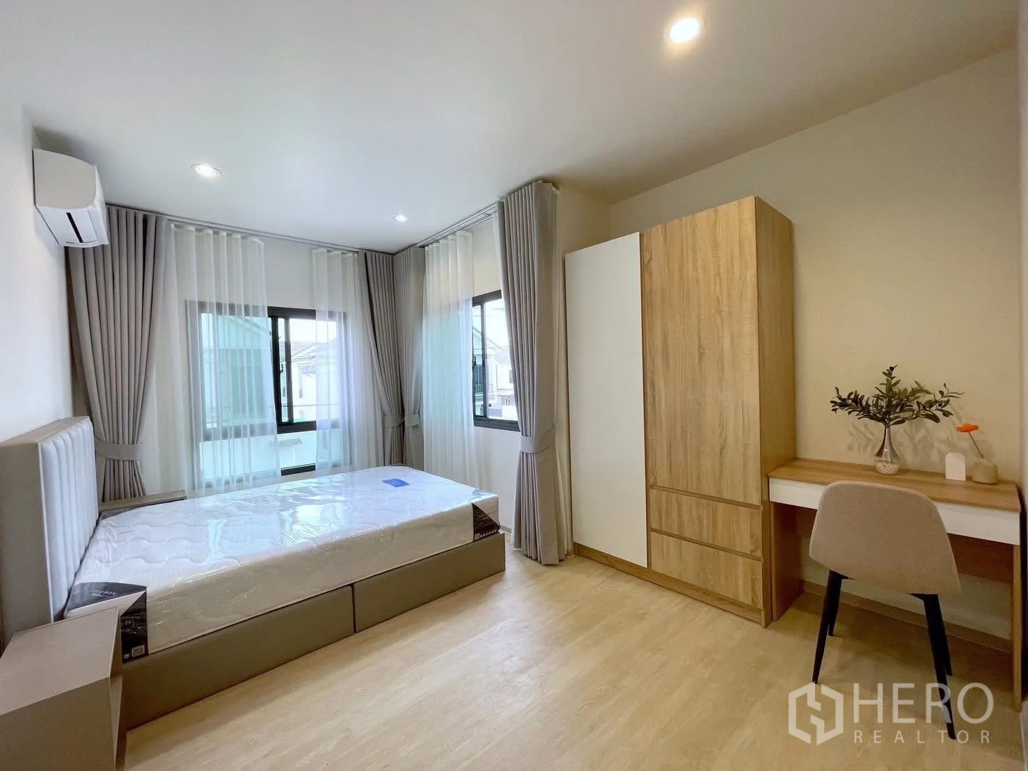 บ้านเดี่ยว for rent in Bang Phli, Samut Prakan - ห้องนอนกว้าง มีหน้าต่างสองด้าน เตียงบุนวม ตู้เสื้อผ้า และโต๊ะทำงาน พื้นสีไม้