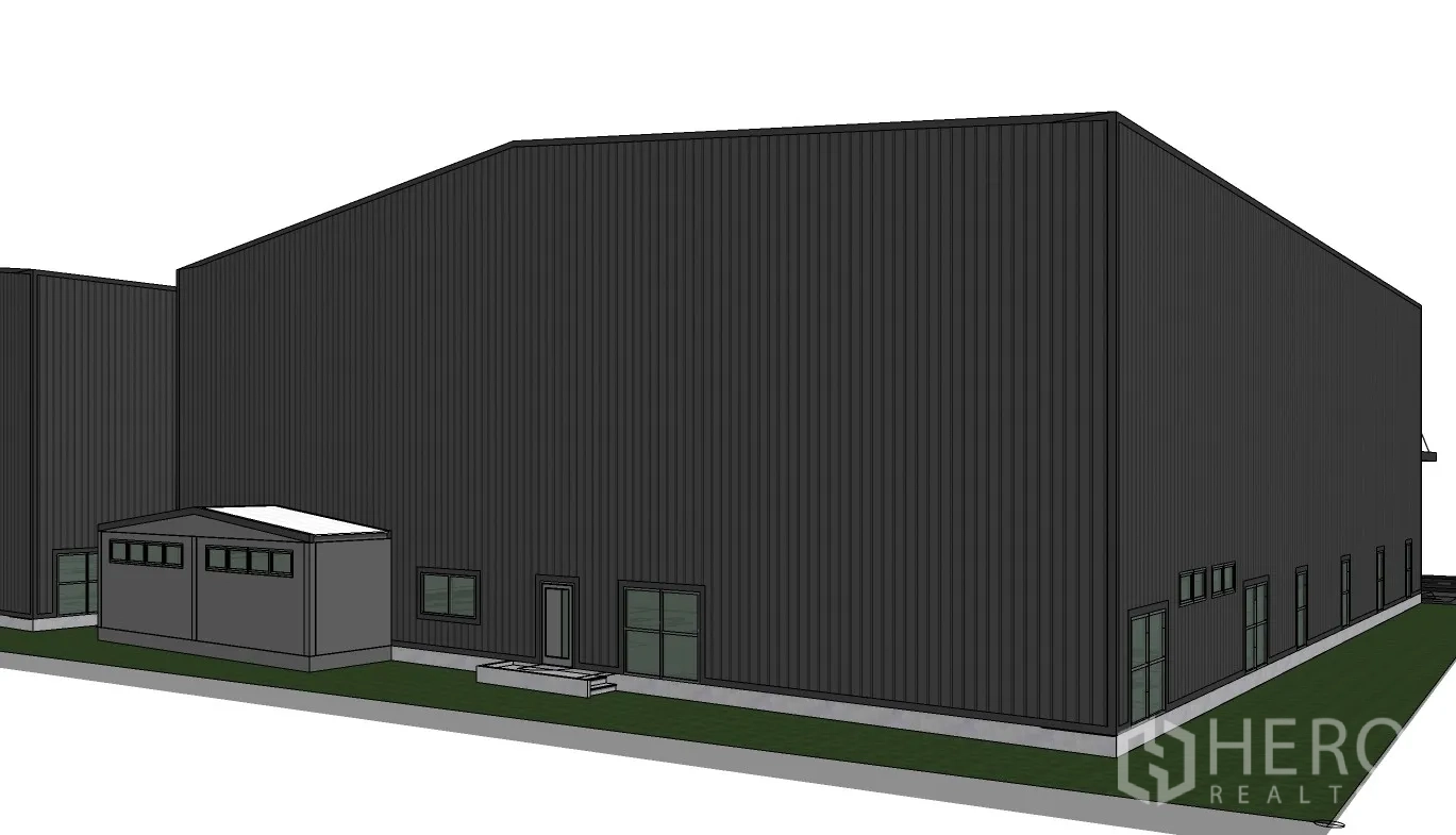 Warehouse for rent in Prawet, Bangkok - Rear and side view showing service doors, low windows, and a small utility building beside the warehouse.