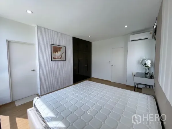 Townhouse for rent in Bang Phli, Samut Prakan - Sunlit master bedroom with large wardrobe, desk and air conditioner.