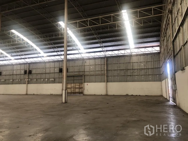 Warehouse for rent in Bang Pa-in, Phra Nakhon Si Ayutthaya - Side view of the warehouse interior with large door, ventilation panels and natural light.