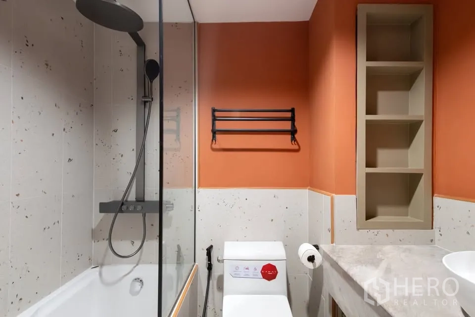 公寓 for rent in Watthana, Bangkok - 浴室带浴缸、顶喷花洒与橙色点缀墙面。
