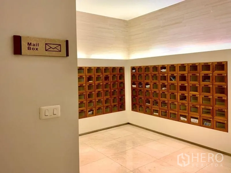 Condominium for rent in Khlong Toei, Bangkok - Mailroom with rows of wooden mailboxes and soft ceiling lighting.