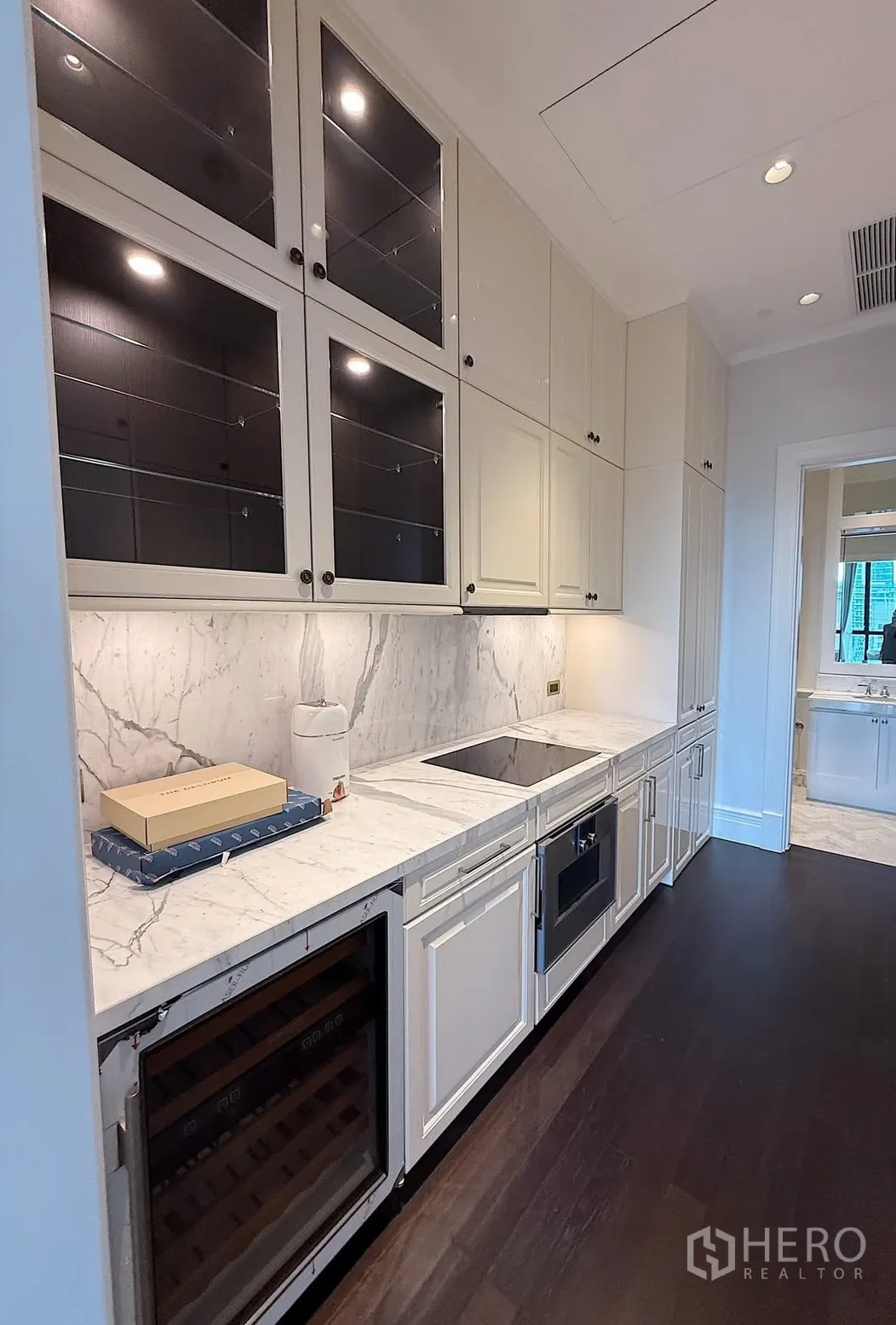 คอนโด for rent or sale in Pathum Wan, Bangkok - มุมครัวที่มีเตาแม่เหล็กไฟฟ้า อ่างล้างจาน เตาอบ และตู้แขวนกระจก