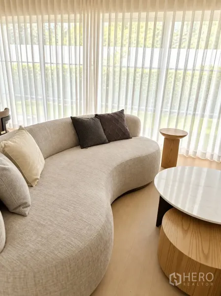 独栋房屋 for rent in Bang Phli, Samut Prakan - 落地窗旁的弧形沙发与套叠圆几。