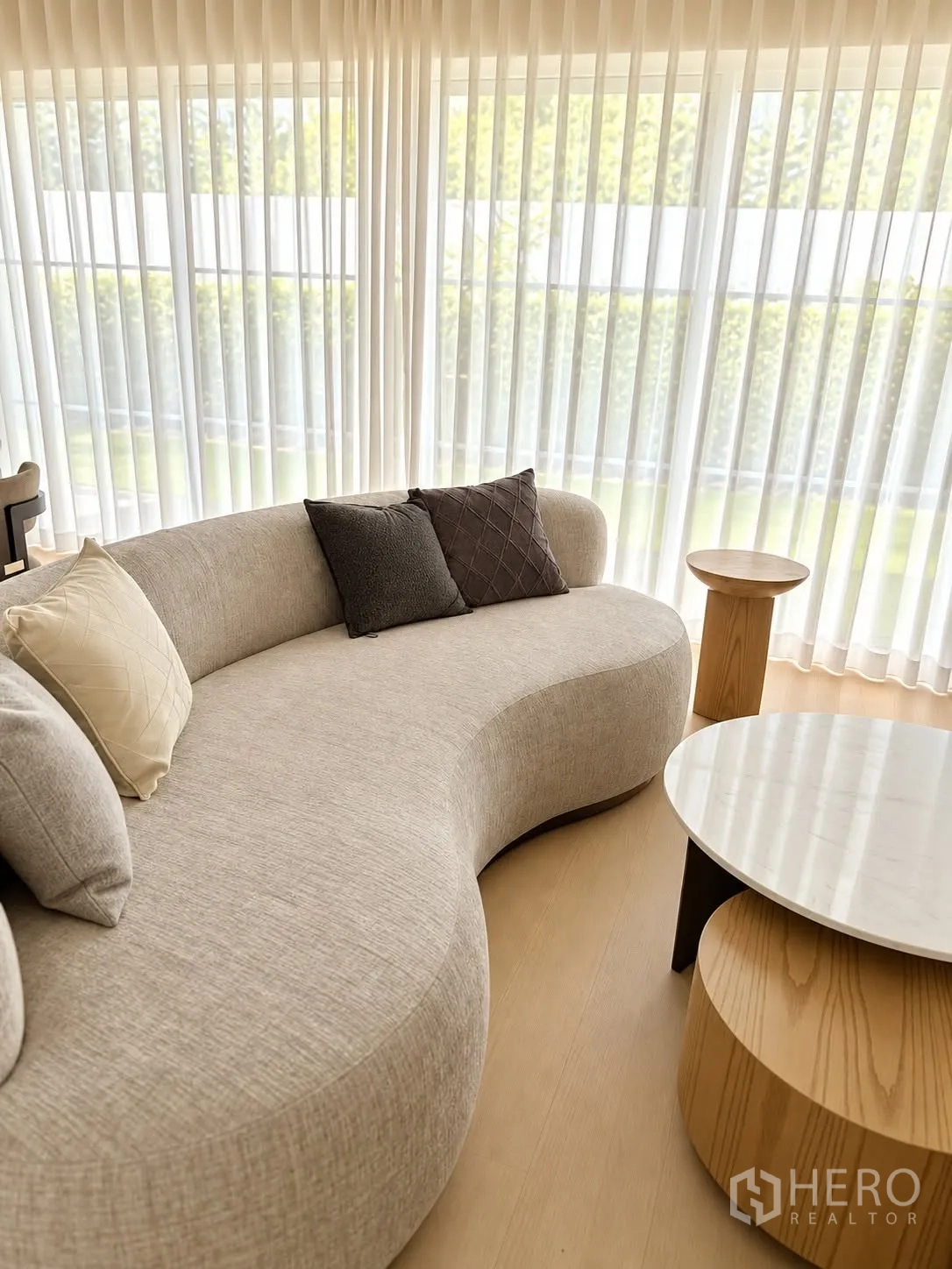 独栋房屋 for rent in Bang Phli, Samut Prakan - 落地窗旁的弧形沙发与套叠圆几。