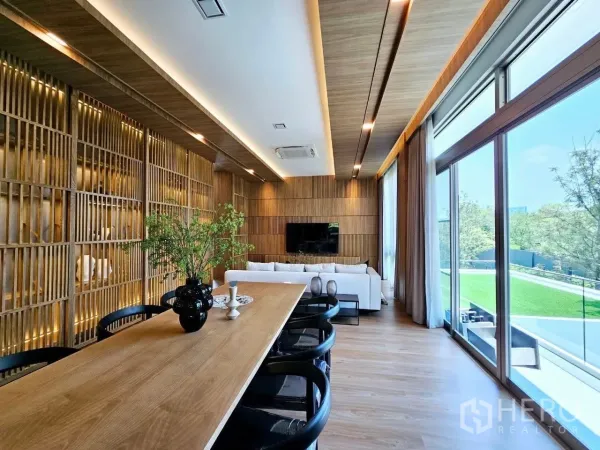 Detached House for rent in Saphan Sung, Bangkok - Long wooden dining table beside full-height glass doors to a terrace.