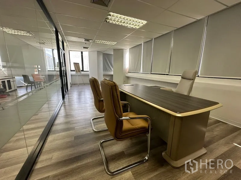 Office Space for rent or sale in Din Daeng, Bangkok - Director’s office beside a glass wall with long desk, visitor chairs and window blinds.
