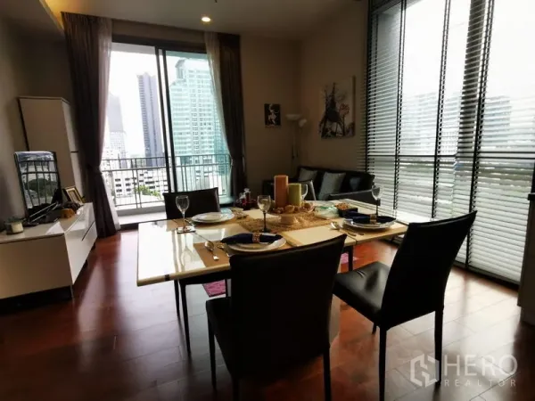 Condominium for rent - Dining table set for four beside a balcony with skyline view.