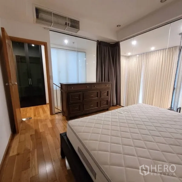 公寓 出租在Khlong Toei, Bangkok - 卧室一角，五斗柜、窗户与温暖木地板。