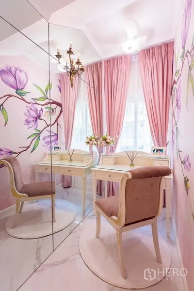 Townhouse for rent in Lat Phrao, Bangkok - Dressing room with floral wall mural, mirrored wall, vanity table and pink curtains.
