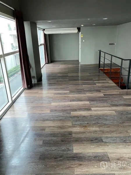 Retail Space for rent in Huai Khwang, Bangkok - Upper mezzanine level with wood floors, stair railing and wide windows.