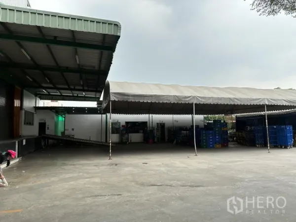 工厂 出租在Lat Krabang, Bangkok - 带大型雨棚的装卸院区，地面开阔，堆放周转箱的食品级工厂。