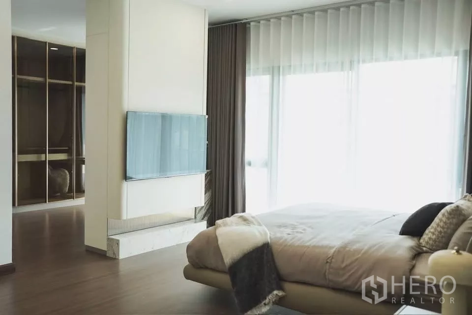 独立式住宅 出租在Bang Phli, Samut Prakan - 宽敞主卧，大窗与柔和窗帘，并连通步入式衣帽间。