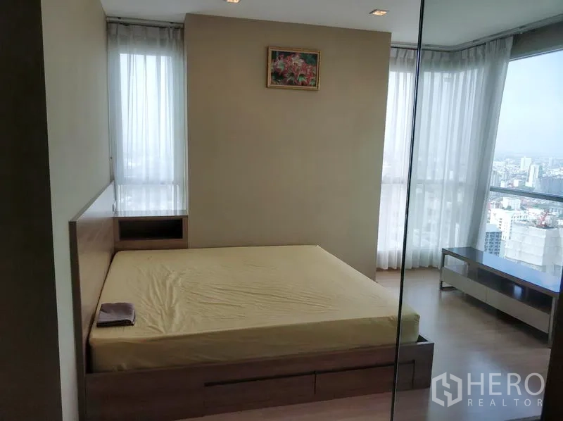 คอนโด ให้เช่าในPhaya Thai, Bangkok - ห้องนอนสว่าง เตียงควีน และหน้าต่างมุมเห็นวิวเมือง