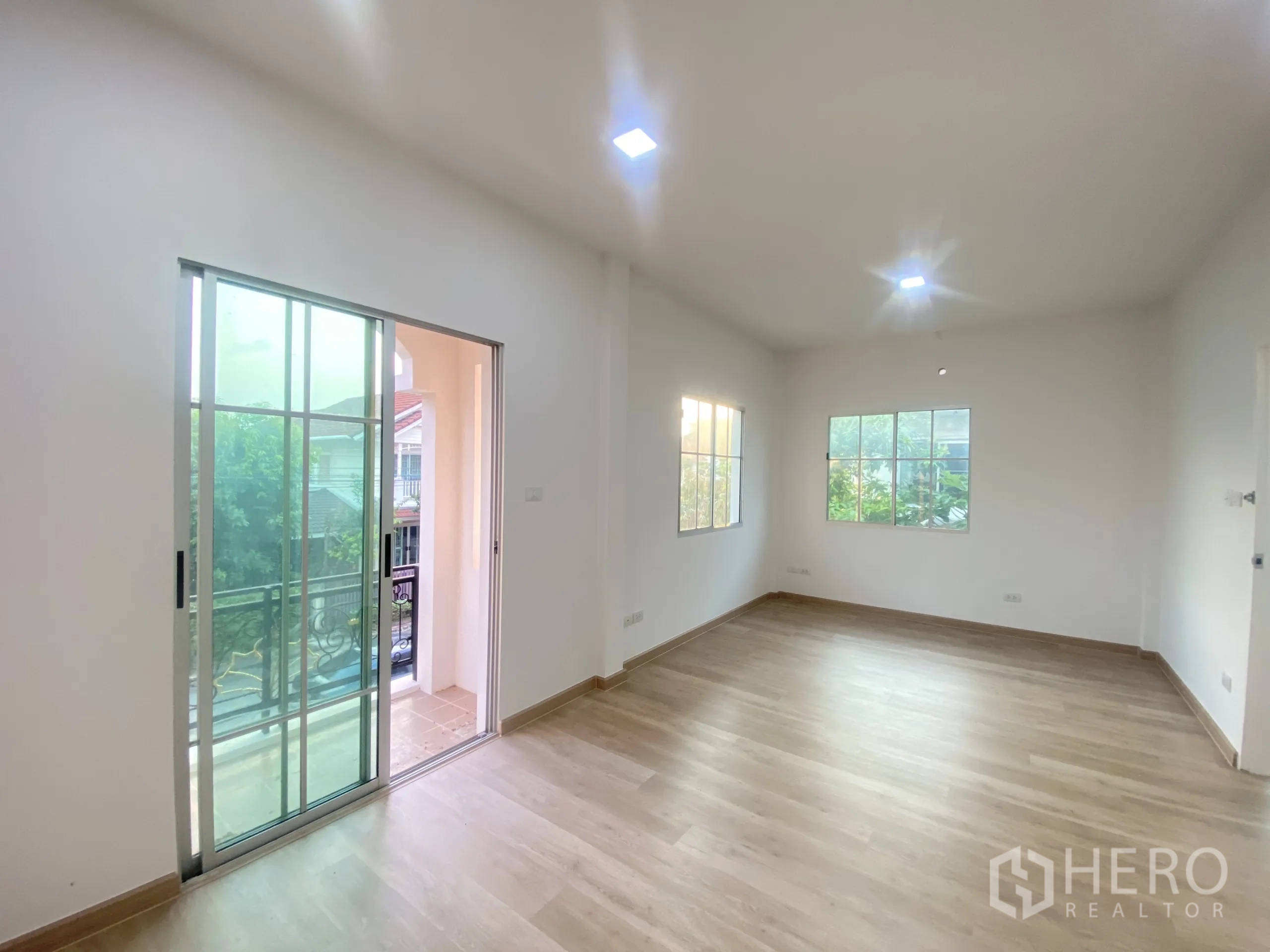 บ้าน ขายในNonthaburi - ห้องนอนใหญ่เชื่อมต่อระเบียงพร้อมพื้นไม้.