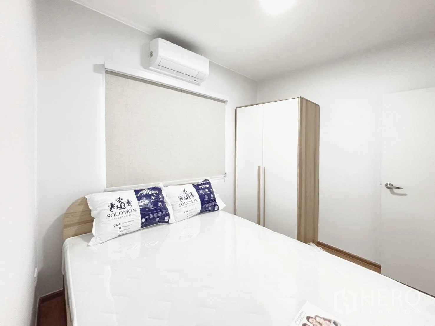 Townhouse for rent in Bang Phli, Samut Prakan - Furnished bedroom with bed, wardrobe, window blind, and wall-mounted air conditioner.