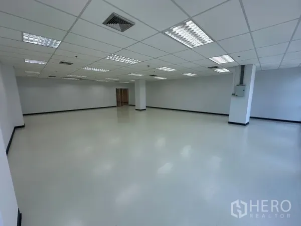 办公空间 出租在Bang Na, Bangkok - 宽敞白色办公内饰，格栅吊顶与荧光照明。