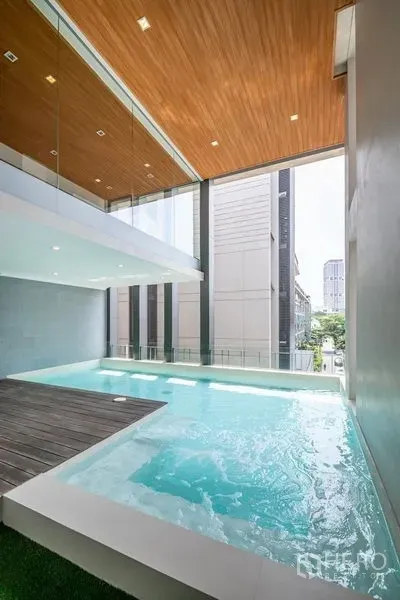 联排别墅 出租在Khlong Toei, Bangkok - 室内外一体的跃层式泳池，高挑木质天花